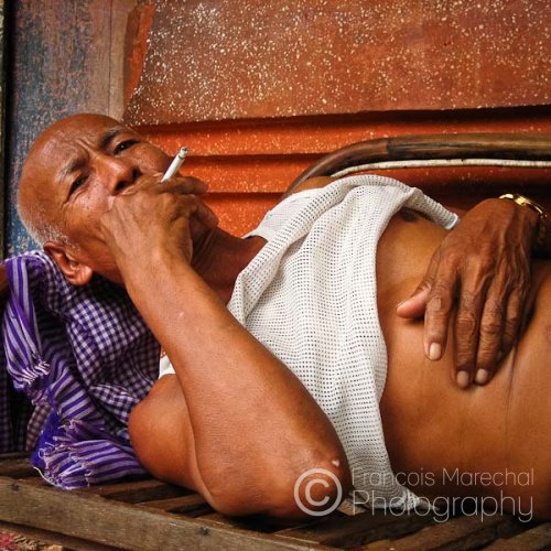 In the heat of the day, this man was simply enjoying a cigarette next to a buddhist monastery in the Roluos Group.