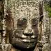 Carved stone faces gaze down from the towers of the Bayon temple. The Buddhist temple was constructed for Jayavaraman VII in the late 12th to early 13th century. It lies in the centre of the capital city, Angkor Thom.