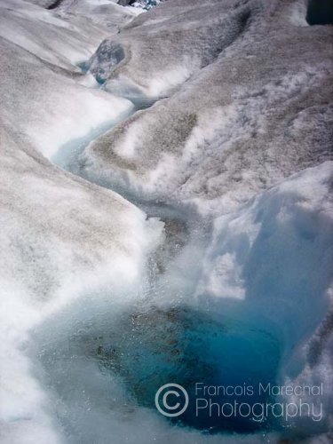 Clear and freezing water from melting snow filling a blue pool.